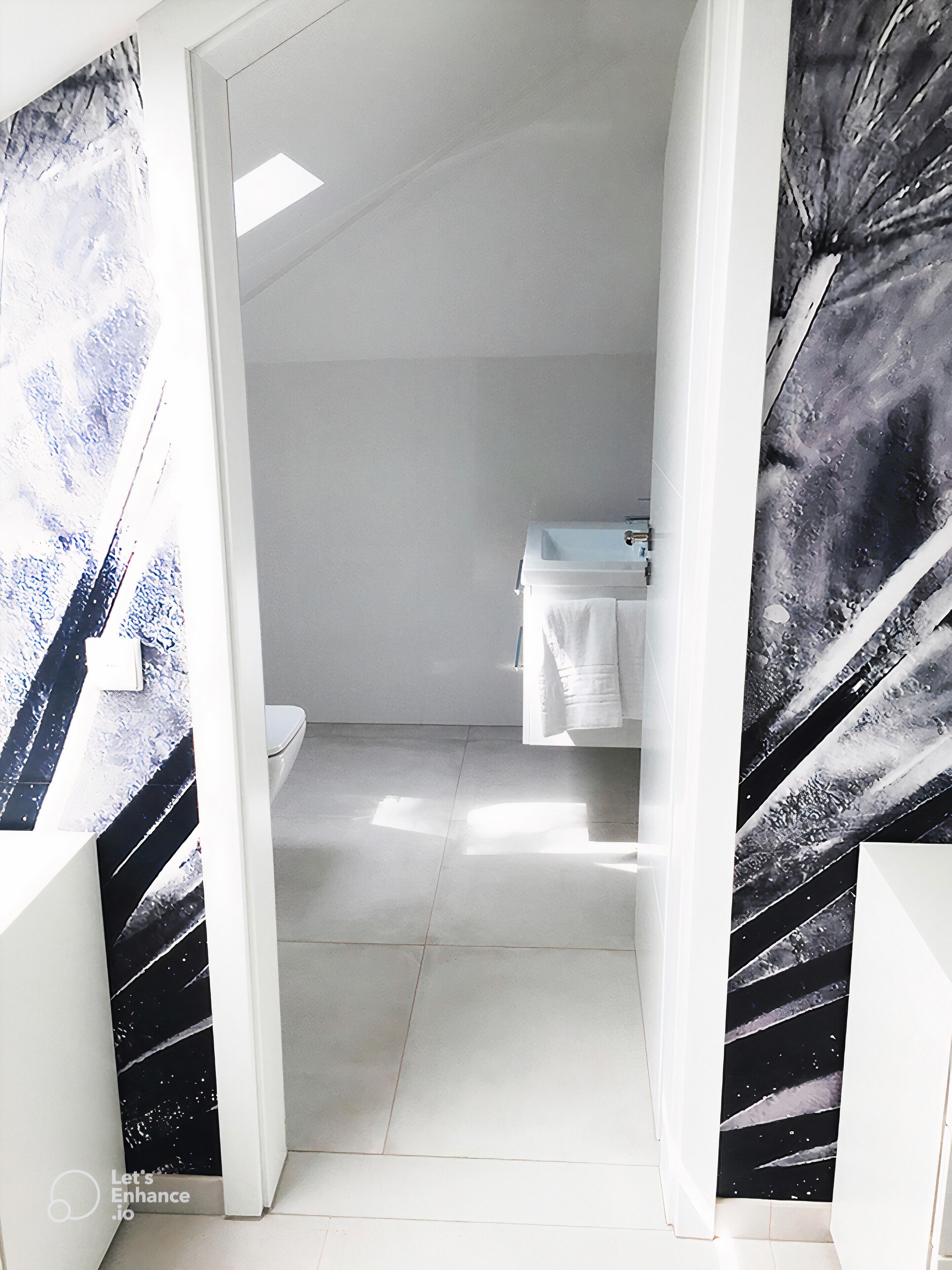 A modern bathroom with a white sink, a toilet, and a shower area.