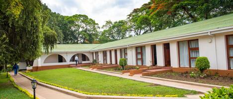 A building with a green roof, white walls, and a central courtyard with a pathway.