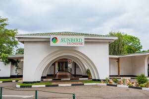 Un edificio con un letrero que dice "SUNBIRD LILONGWE" y una entrada en arco.
