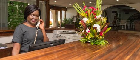 A reception desk with a telephone, a printer, and a floral arrangement.