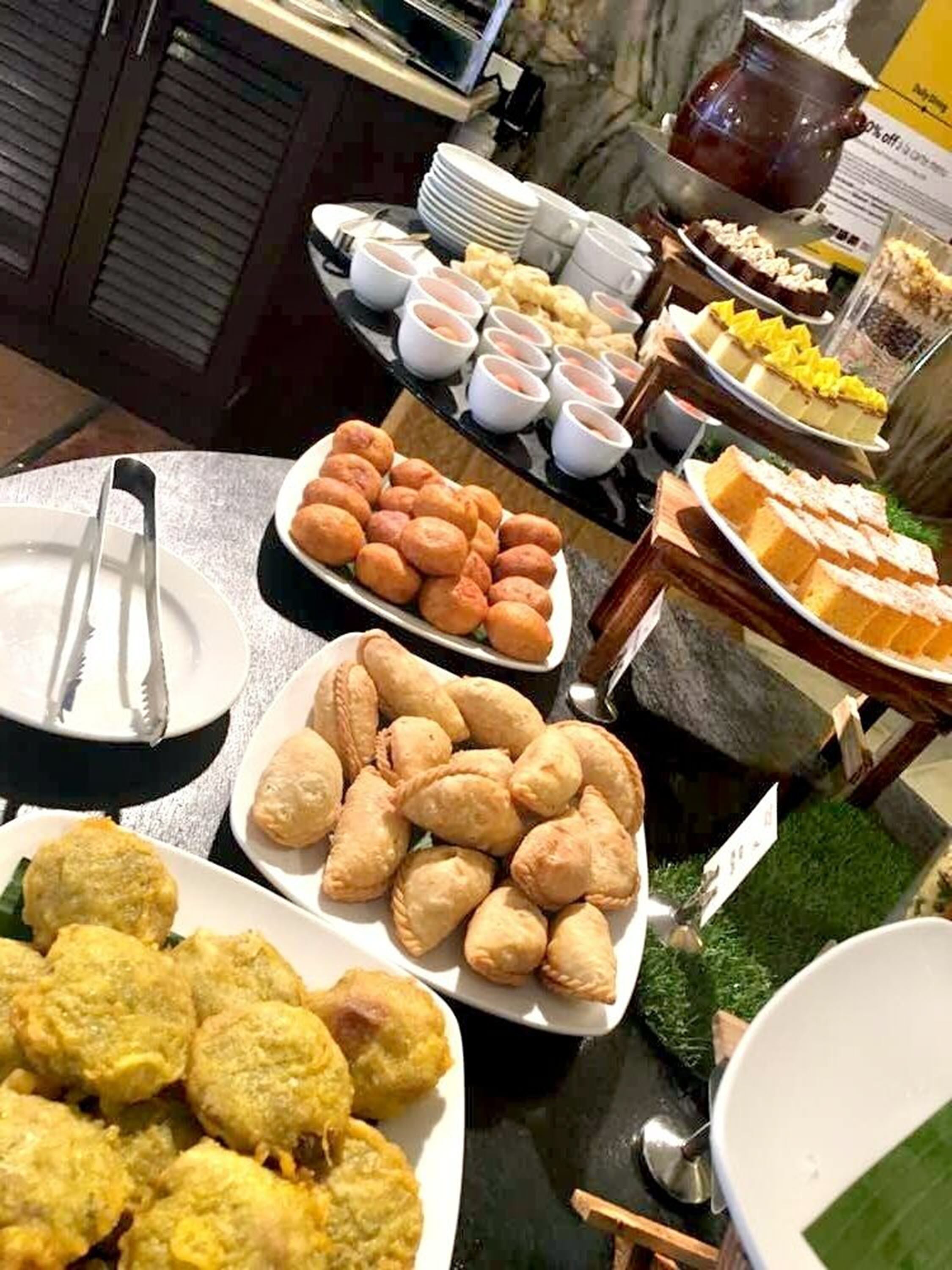 A buffet with various dishes including bread, pastries, and dips.