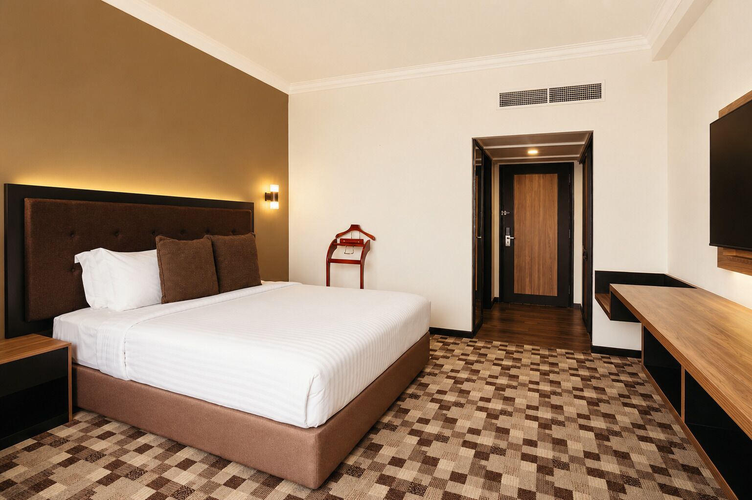 Une chambre d’hôtel avec un grand lit, une table de chevet en bois, une télévision et un sol à carreaux.