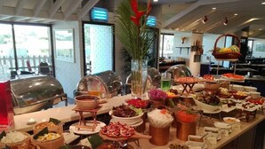 Un bufé con diversos alimentos y una estación de parrilla.