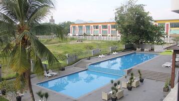 Relax by the rectangular pool surrounded by lounge chairs and lush greenery.