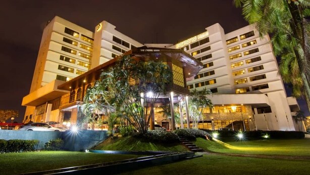 Un hotel moderno con un atrio central, varios pisos y una entrada bien iluminada.