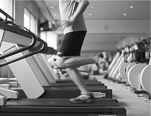 A person running on a treadmill in a gym with exercise equipment in the background. - Conrad Kuala Lumpur (Kuala Lumpur)