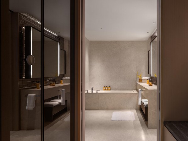 A modern bathroom with a large mirror, a bathtub, and a shower area. - Conrad Kuala Lumpur (Kuala Lumpur)