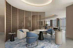 A modern interior with a curved wall, seating area, and a round table. - Courtyard by Marriott Kuala Lumpur City Centre (Kuala Lumpur)