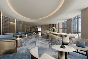 A modern hotel lobby with seating areas, a reception desk, and large windows offering city views. - Courtyard by Marriott Kuala Lumpur City Centre (Kuala Lumpur)