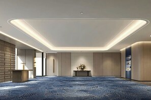 A spacious room with a patterned carpet, recessed ceiling lighting, and a central console table with a vase of flowers. - Courtyard by Marriott Kuala Lumpur City Centre (Kuala Lumpur)