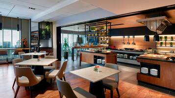 Un restaurante moderno con una isla central, zona de estar y cocina a la vista.