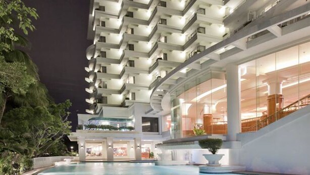 A modern hotel with a large indoor swimming pool, multiple balconies, and a well-lit lobby area. - Dorsett Grand Labuan (Labuan)