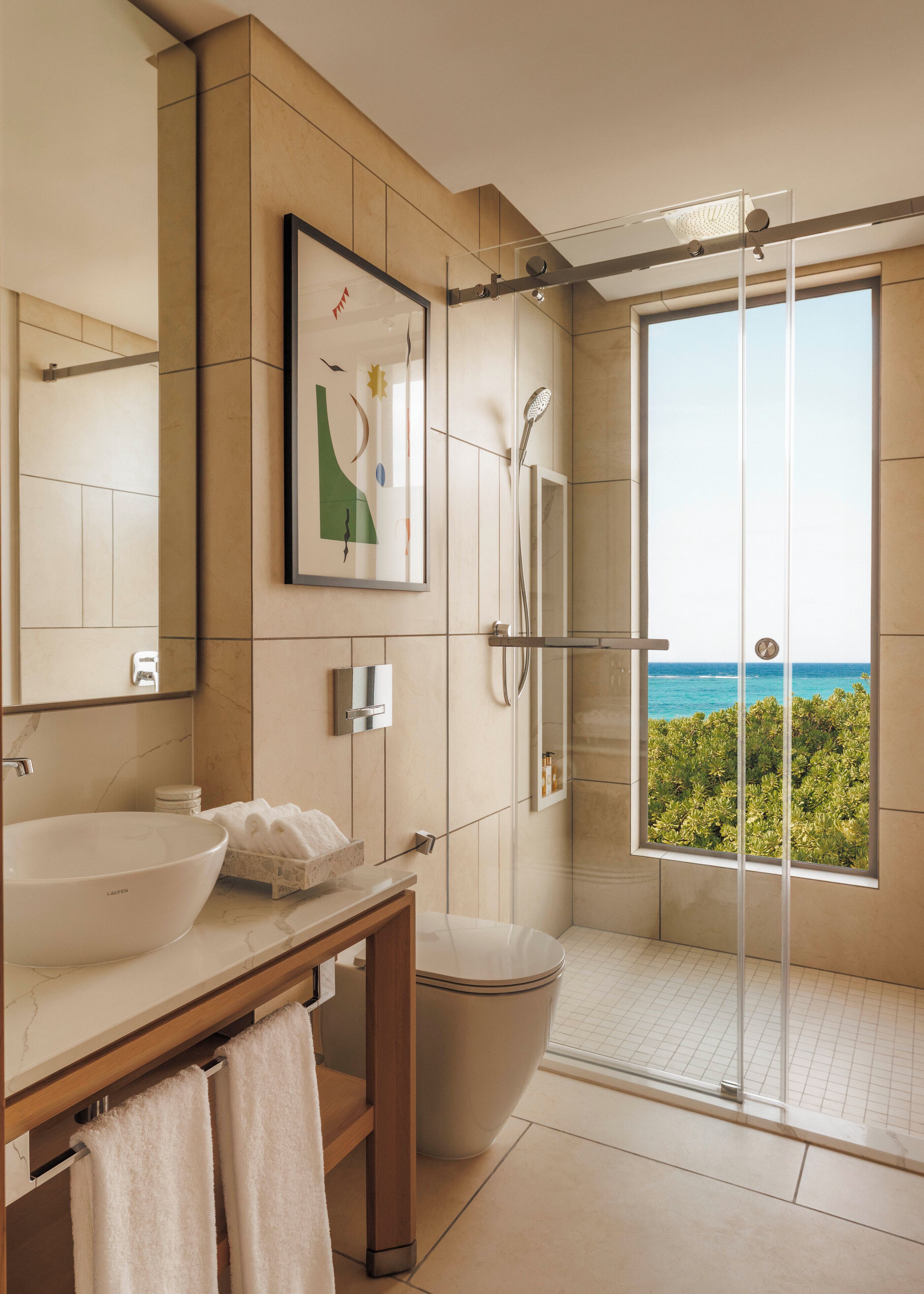 A modern bathroom with a large sink, mirror, and a shower with a glass door.