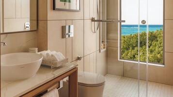 A modern bathroom with a large sink, mirror, and a shower with a glass door.