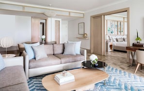 A modern living room with a sofa, coffee table, and a dining area.
