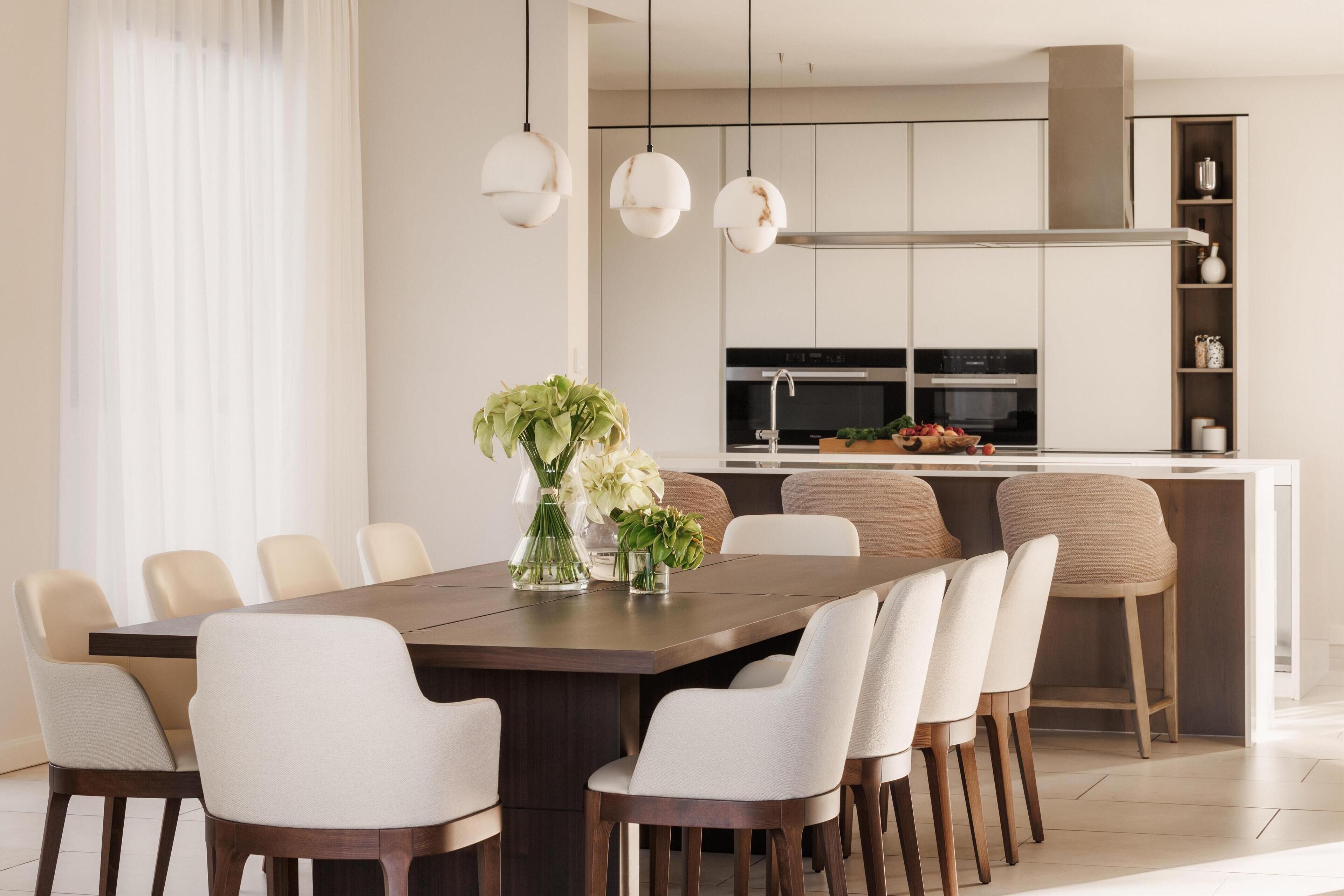 A modern kitchen with a central island, white cabinetry, and pendant lighting.