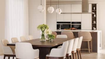 A modern kitchen with a central island, white cabinetry, and pendant lighting.