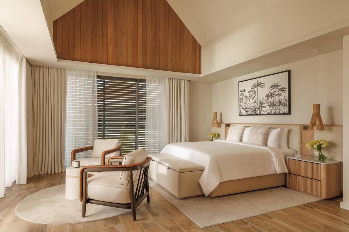 Un dormitorio moderno con una cama grande, techo de madera y un cuadro en la pared.