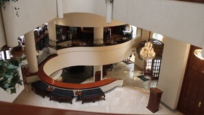 A multi-level interior with a curved staircase, seating areas, and a chandelier. - Hotel Imperial Reforma (Mexico City)