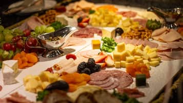 A charcuterie board with various cheeses, meats, fruits, and vegetables.