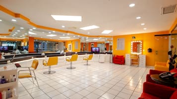 Un salone con diversi posti a sedere, specchi e un’area reception.
