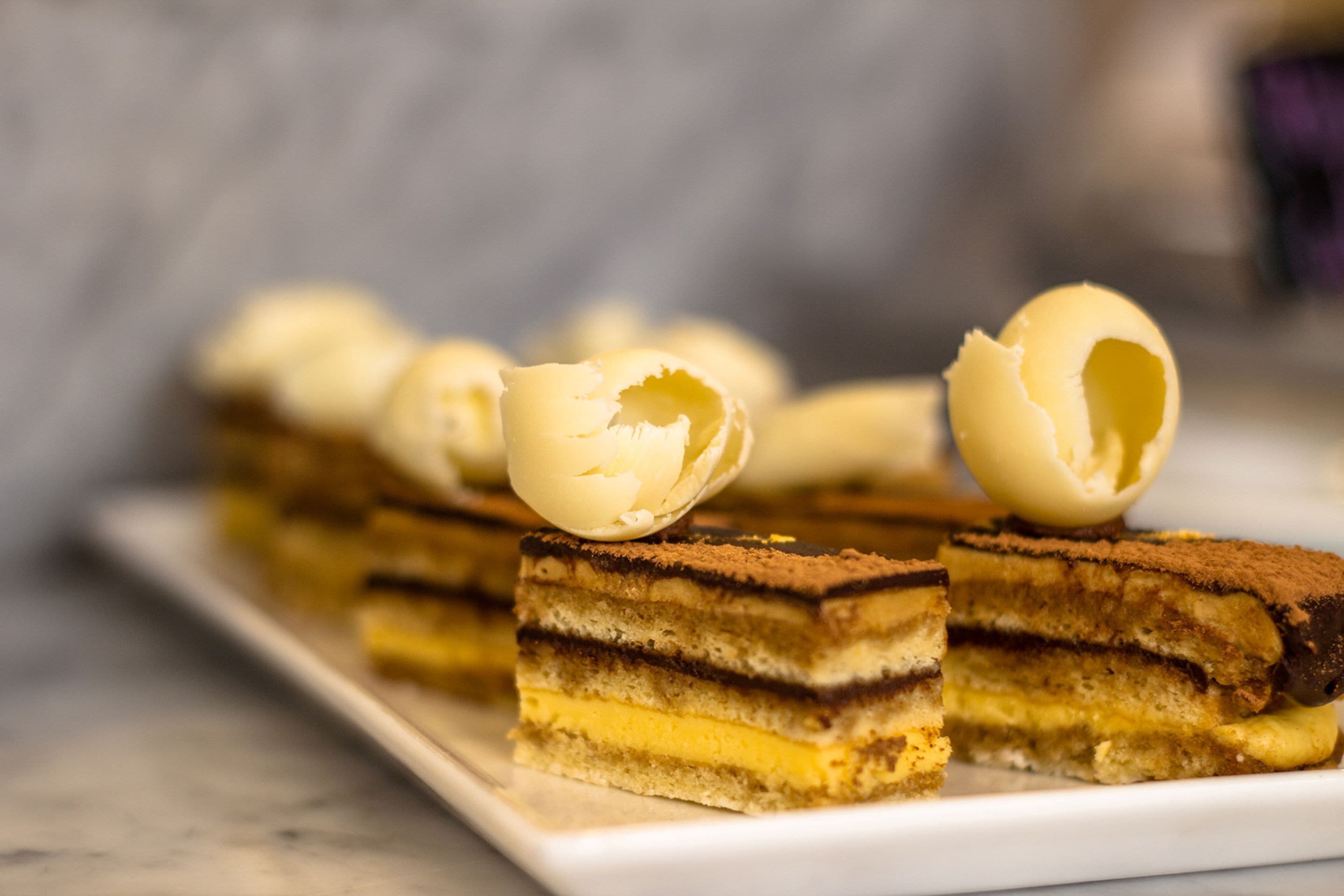 A dessert with multiple layers and a cracked egg on top.