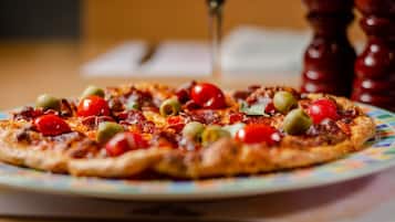 A pizza with various toppings on a colorful plate.