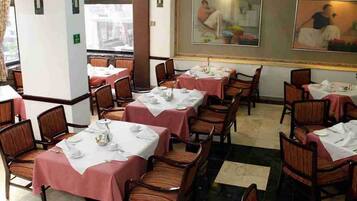 A dining area with tables set for service, chairs, and a checkered floor.