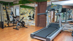 A gym with a treadmill, stationary bikes, and various exercise machines.