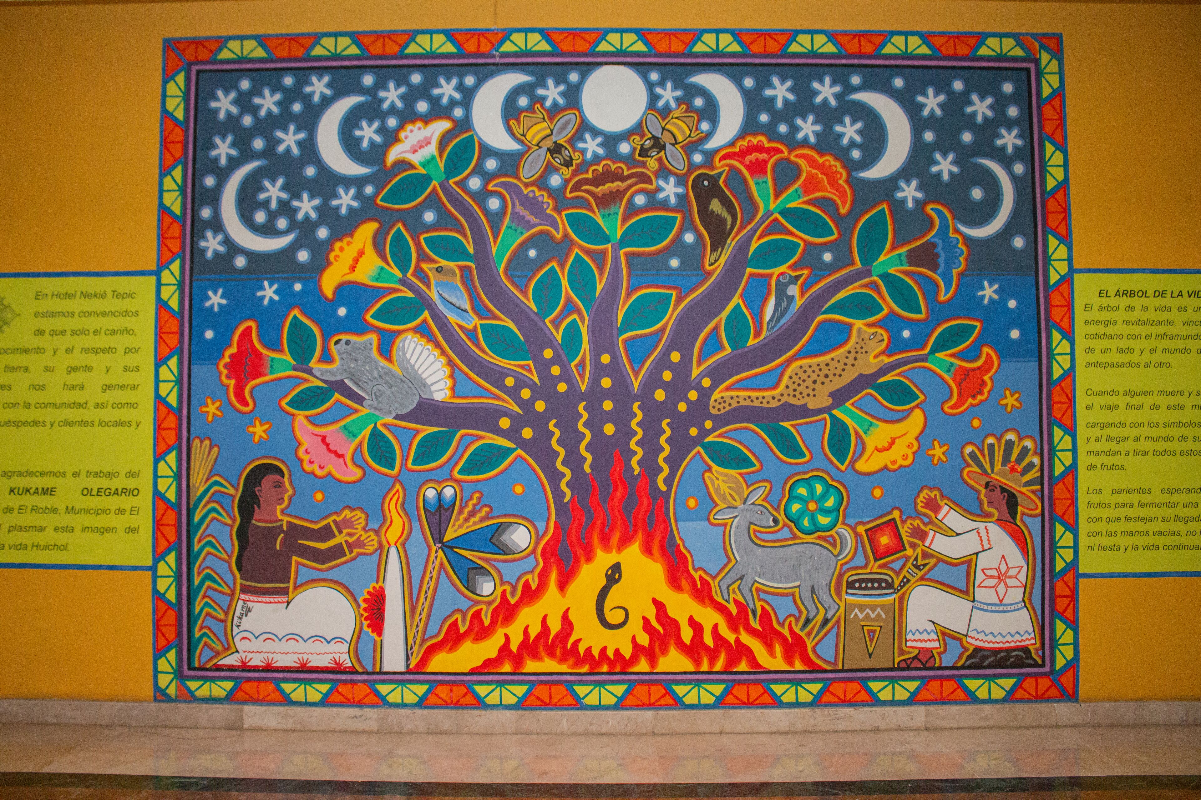 A colorful mural with a tree at its center, surrounded by various animals and figures.