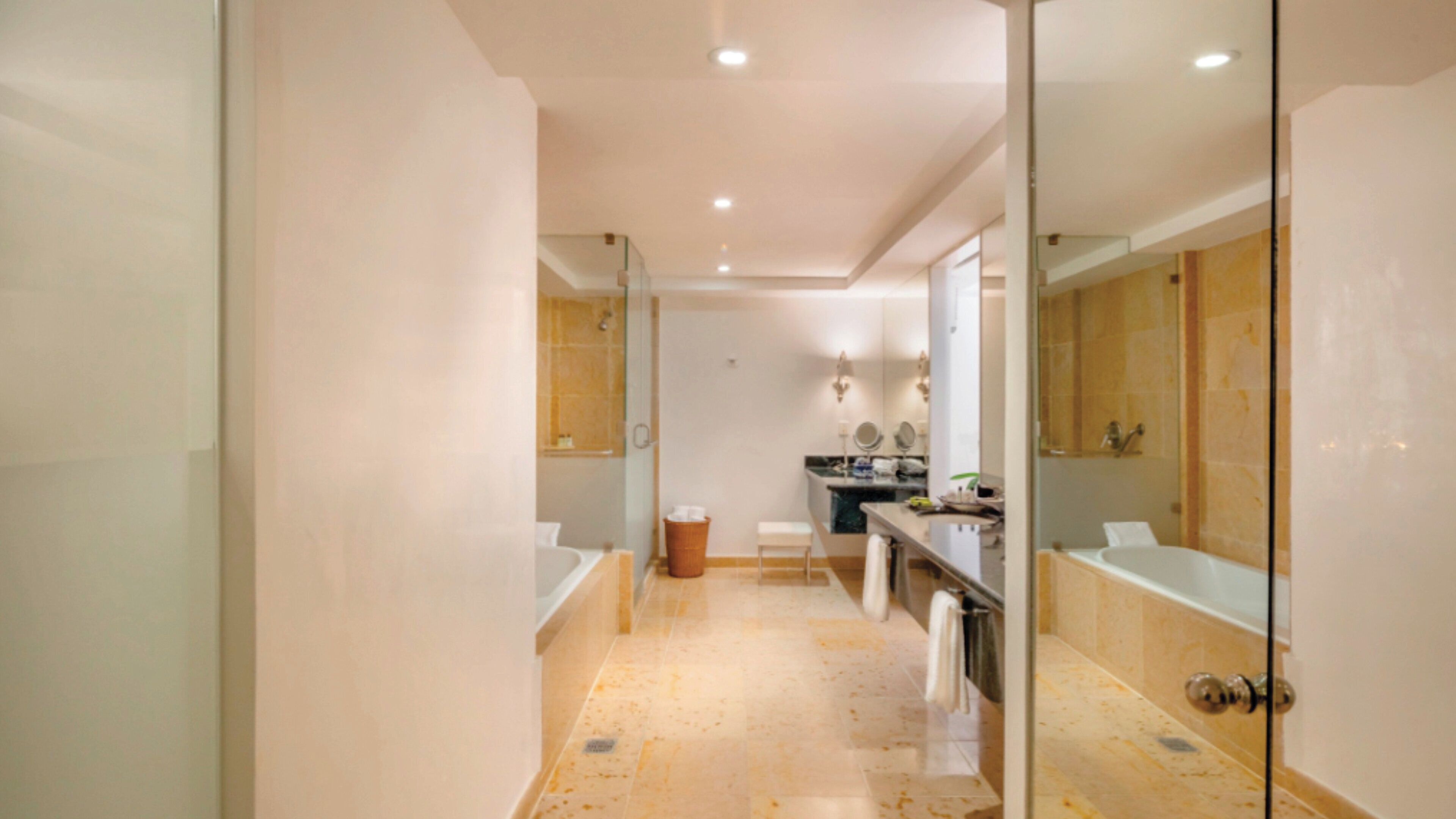 A modern bathroom with a glass partition, a sink, a mirror, and a shower area.