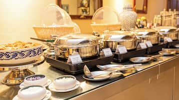 A buffet with various food items and serving utensils.