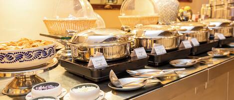 A buffet with various food items and serving utensils.
