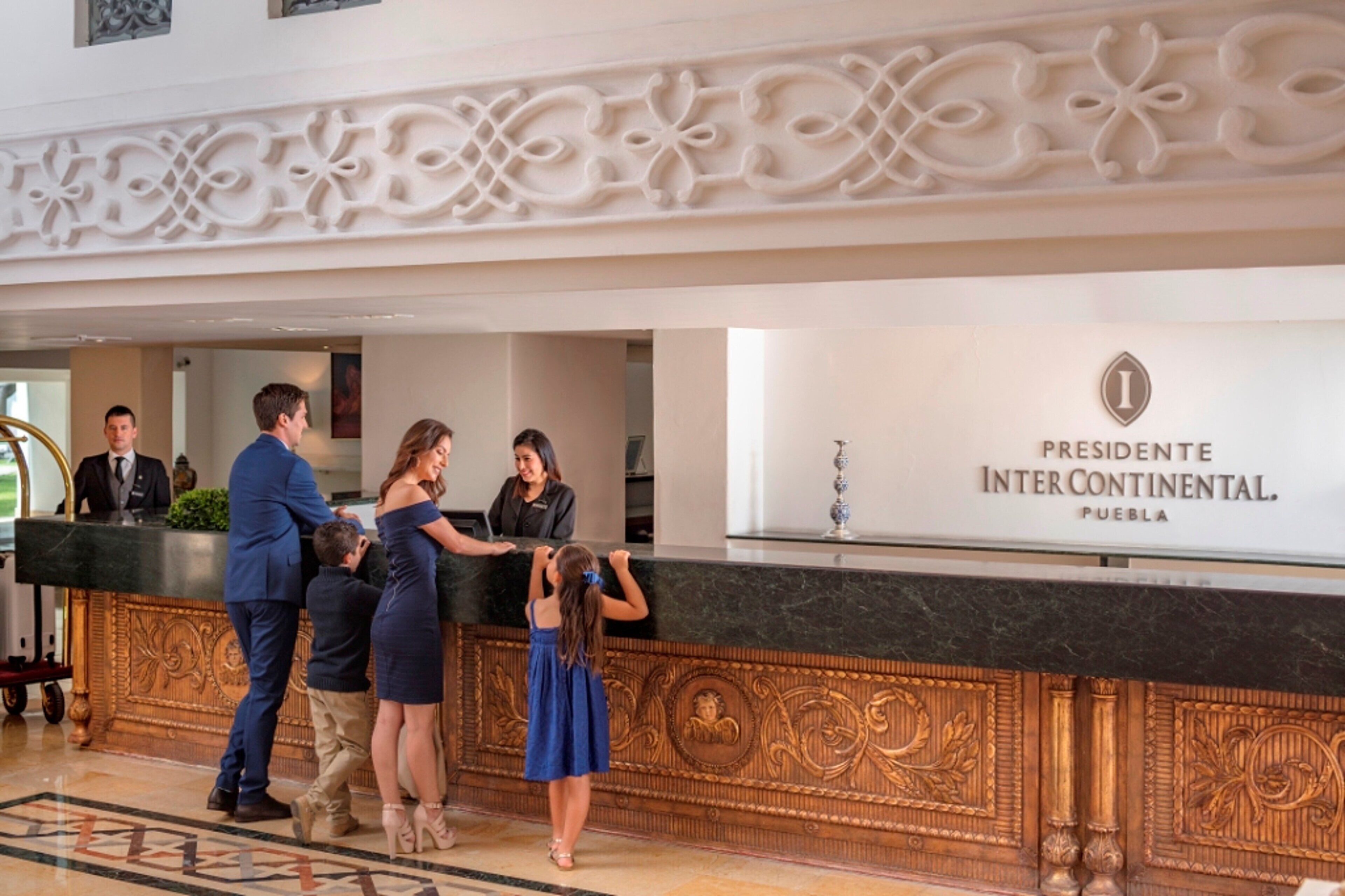 A reception desk with a sign reading "Presidente Inter Continental, Puebla".