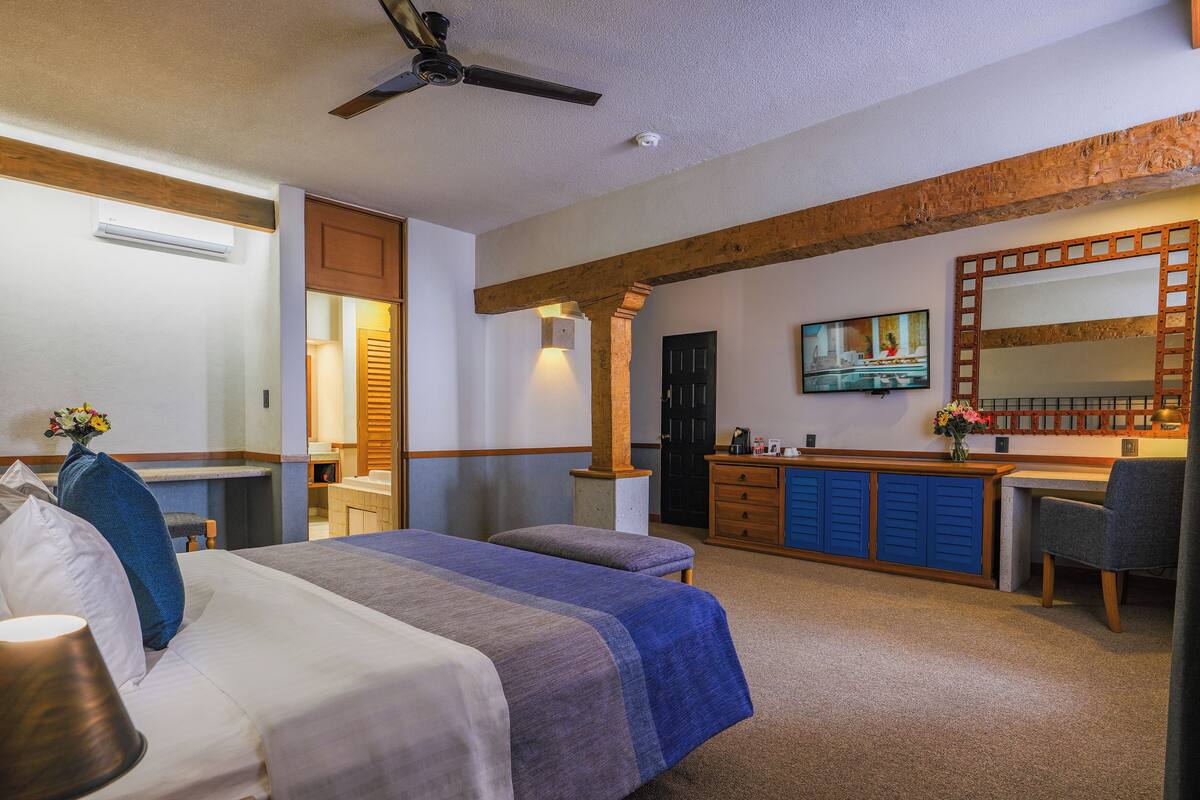 Una habitación de hotel con cama, escritorio y televisor.