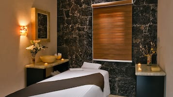 Relax in a serene space with a large bed, bedside table, and wall-mounted mirror.
