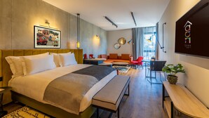 Une chambre d’hôtel moderne équipée d’un grand lit, d’un bureau, d’un canapé et d’un coin repas.