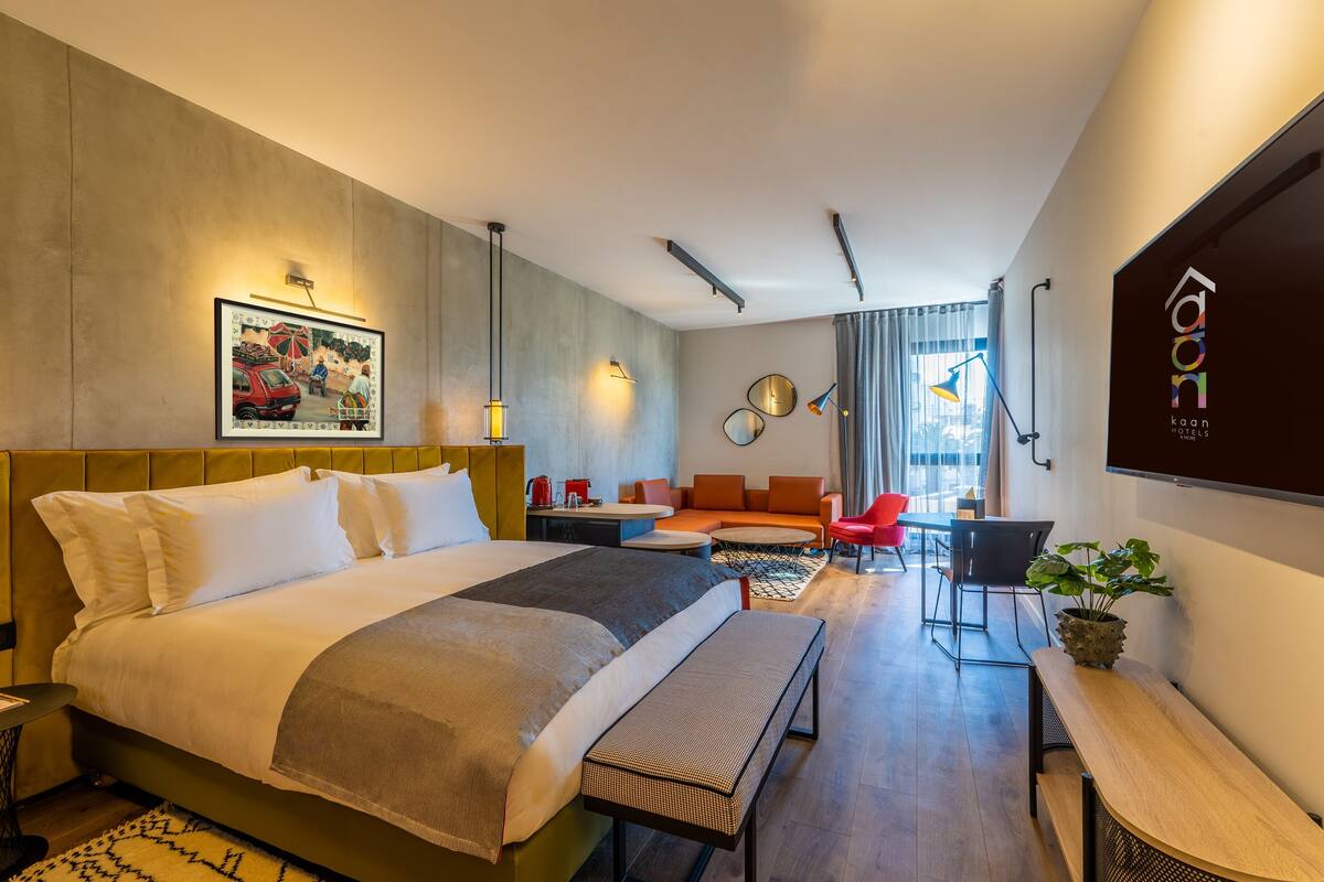 Een moderne hotelkamer met een groot bed, een bureau, een bank en een zithoek.
