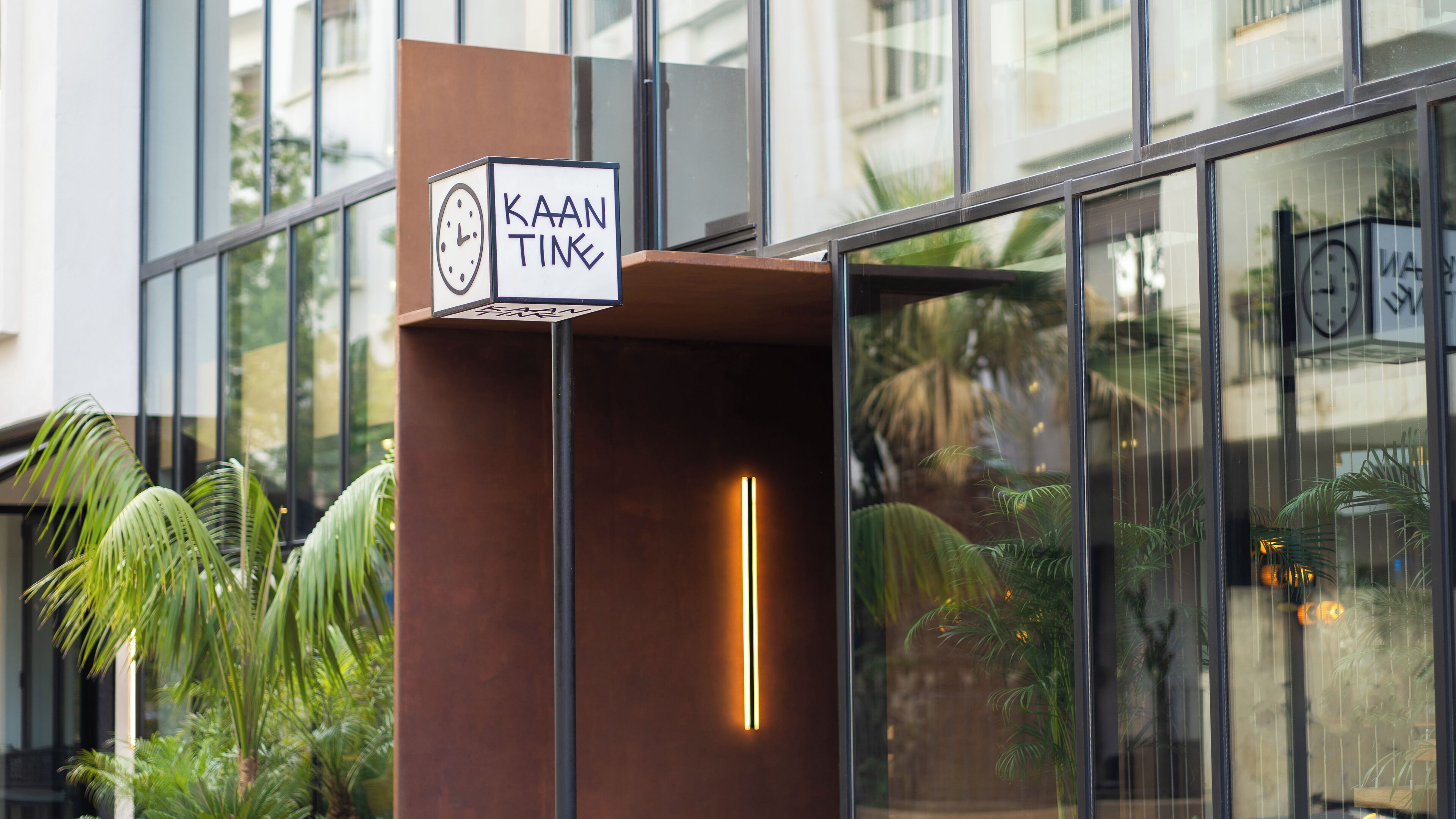 A modern building with a sign reading "KAAN TINKL" and a clock.
