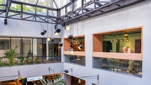 Un intérieur moderne doté d’un atrium central, de plusieurs niveaux et de divers espaces de détente.