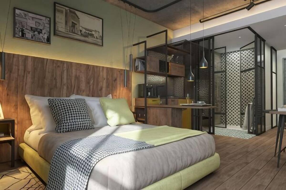 Een moderne slaapkamer met een groot bed, een houten hoofdbord en een ingebouwde werkplek.