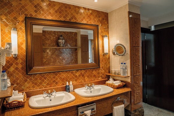 Baño con dos lavamanos, un espejo grande y un perchero para toallas.