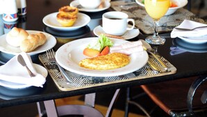 A breakfast table set with plates, cups, and a glass of orange juice. - Pestana Rovuma (Maputo)