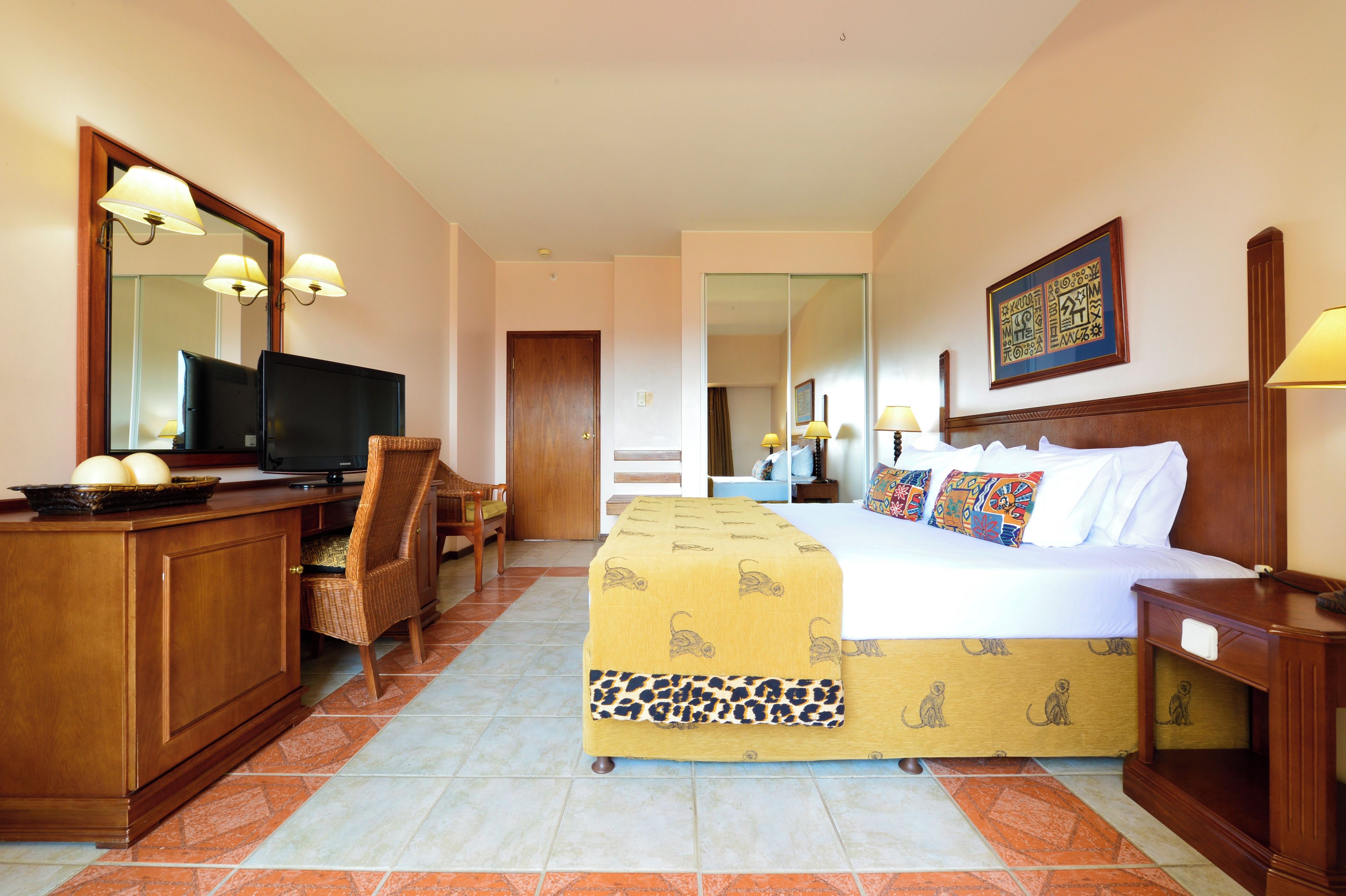 A hotel room with a bed, a television, a desk, and a chair.