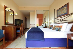 A hotel room with a bed, a desk, a chair, a television, and a mirror.