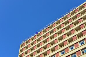 Un edificio de hotel de varios pisos con un cielo azul despejado al fondo.