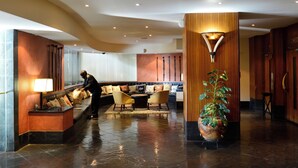A lobby with a reception desk, seating area, and a large potted plant. - Pestana Rovuma (Maputo)