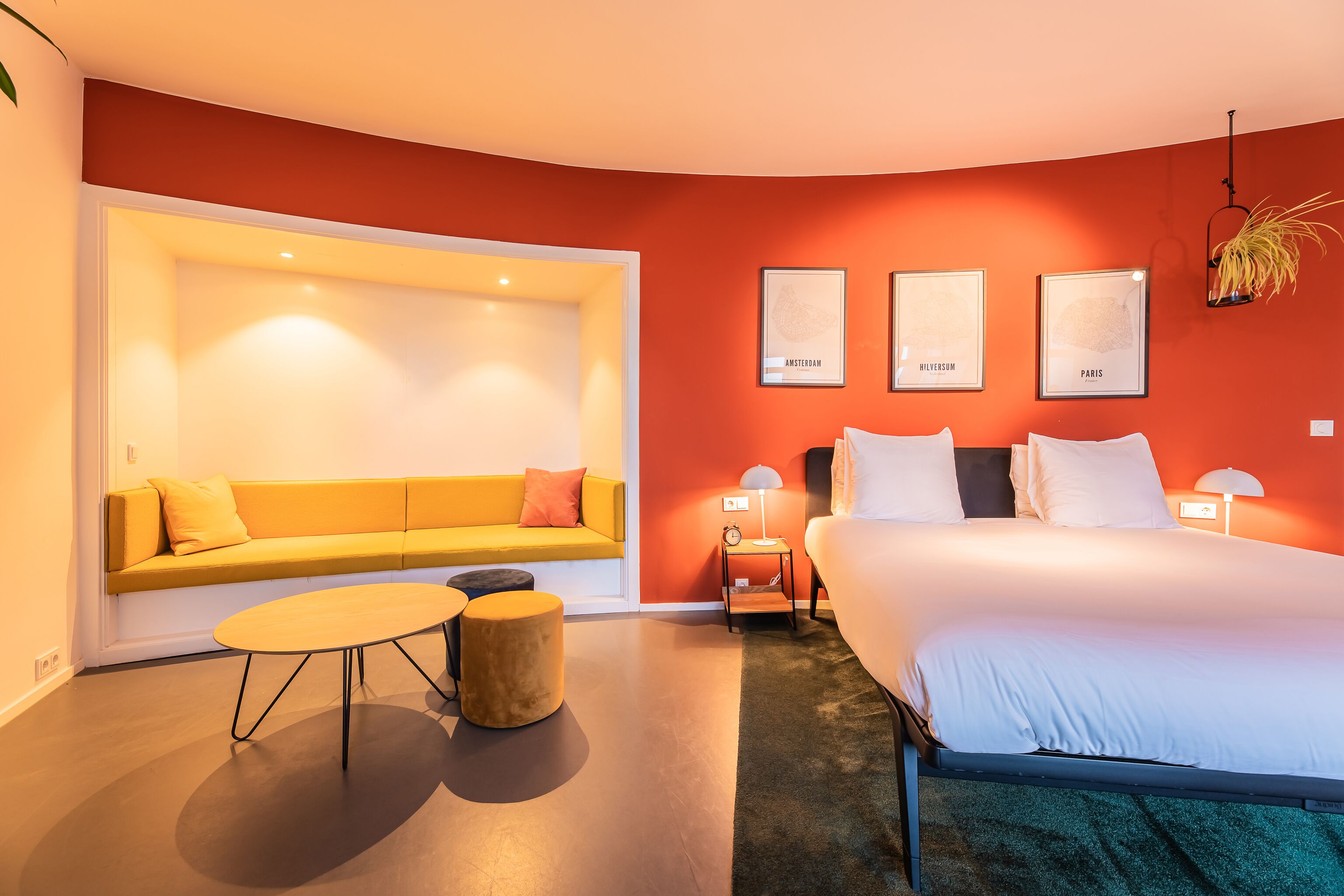 Ein modernes Schlafzimmer mit Sofa, Bett und einem kleinen Tisch.