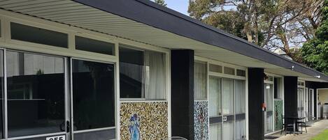 A modern building with large sliding glass doors, numbered 855, and a tiled mosaic wall.