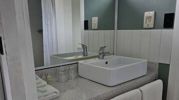 A bathroom with a white sink, a mirror, and a towel rack.